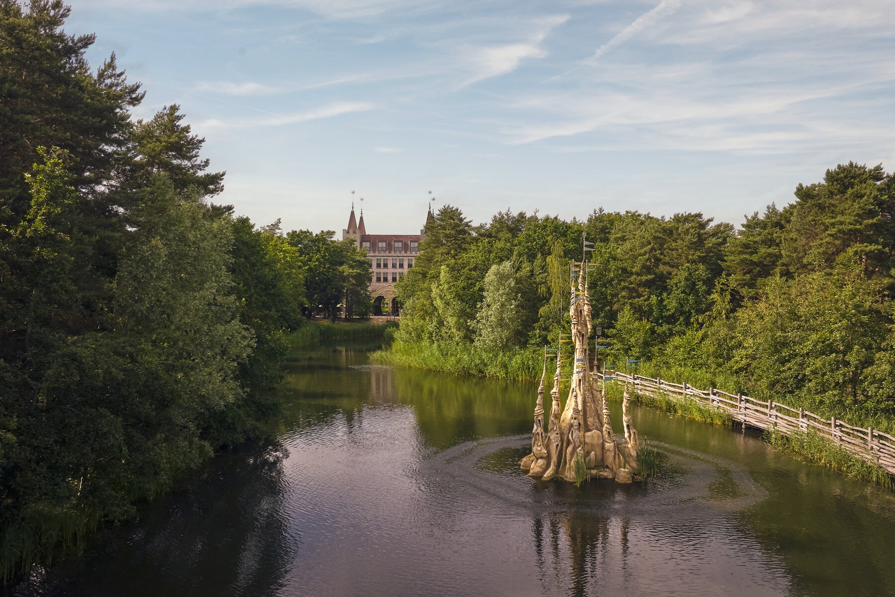 Dronebeeld van de vijver in vakantiepark Efteling Bosrijk met Kasteel Klaas Vaak in het midden en het Poorthuys op de achtergrond.
