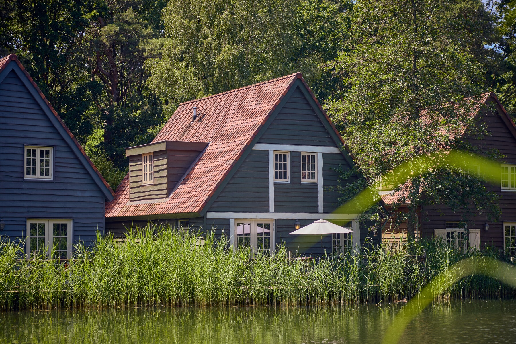 Een 8-persoons Boshuys van Efteling Bosrijk ligt tussen het groen met een eigen terras aan het water.