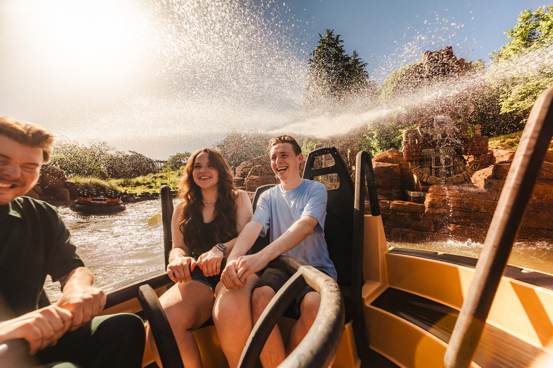 Gasten varen lachend in Piraña langs een waterspuitend Incabeeld in Efteling Park.