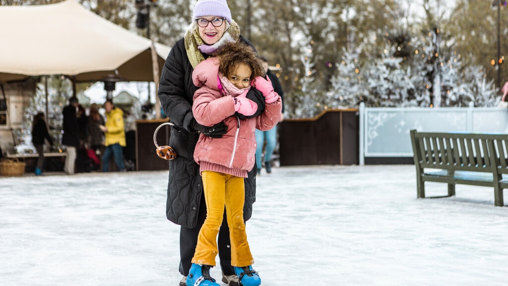 Oma knuffelt meisje op de schaatsbaan tijdens de Winter Efteling