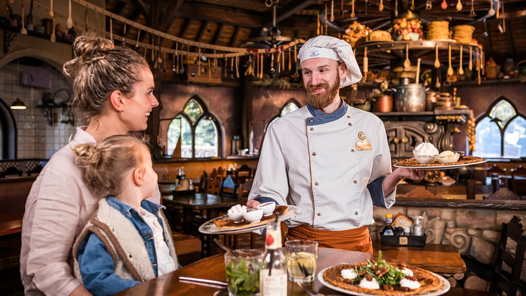 Medewerker die gasten bedient in Polle's Keuken in de Efteling