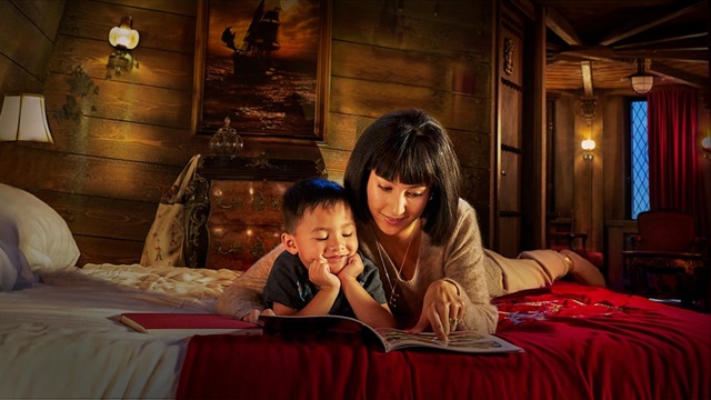 Moeder en zoon lezen op bed een boek in De Vliegende Hollander van het Efteling Hotel