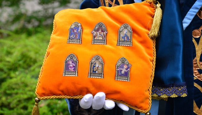 Een oranje kussen met Symbolica Pins erop