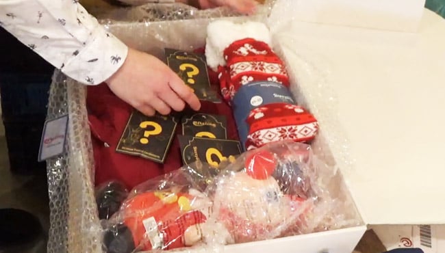 Een medewerker van het Pakhuys pakt een doos in.