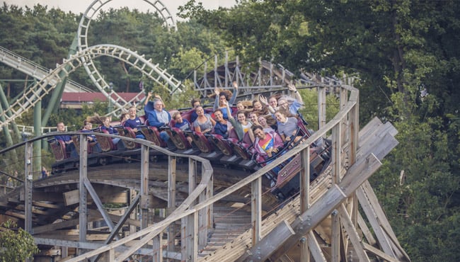 Blije gasten zitten in de achtbaan Joris en de Draak