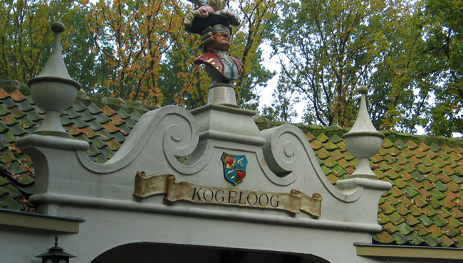 Kogeloog, één van de zes Dienaren stond vroeger een aantal jaar naast Langnek in het Sprookjesbos en vond daarna zijn plek op het dak boven de toegang naar het winkeltje. 