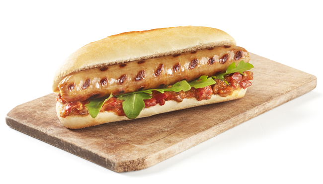 Bijschrift: Een braadworst smaakt nog lekkerder met een laagje tomatenchutney en rucola. Je eet deze zomerspecial bij De Steenbok.