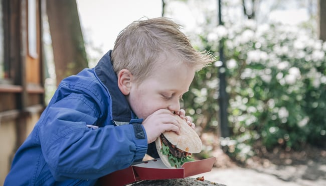 jongen eet hamburger