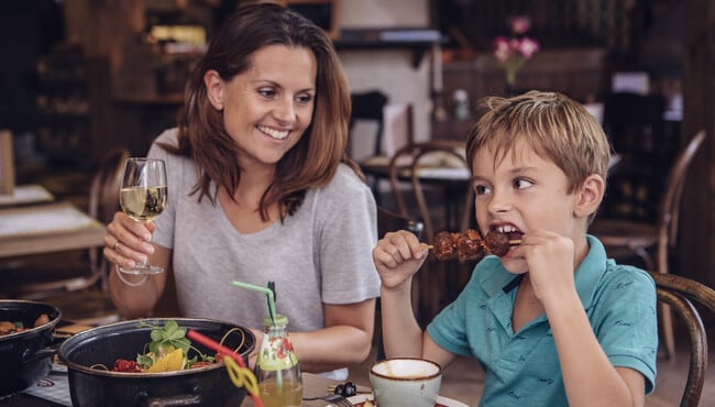 Moeder en zoon eten een hoofdgerecht