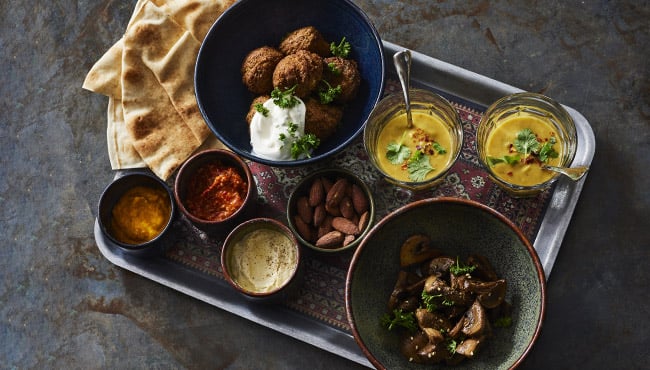 hartige borrelplank met een linzensoepje, falafel, platbrood en verschillende dips