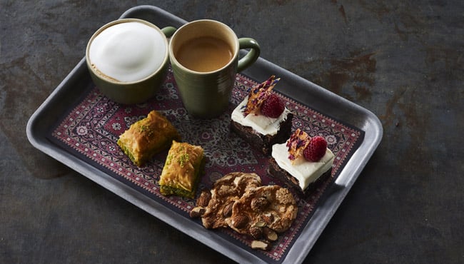 zoete koffieplank met baklava, florentine koekjes en een brownie