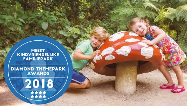Twee kinderen bij een Paddenstoel in de Efteling, met de button voor het meest kindvriendelijke familiepark.