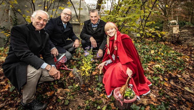 Gerd Leers (voorzitter Stichting Natuurpark de Efteling) en Roodkapje planten onder toeziend oog van Fons Jurgens (Algemeen Directeur Efteling) en Henk Kivits (voorzitter Raad van Commissarissen Efteling) een aantal asters op de bouwplaats van het sprookje De zes Zwanen.