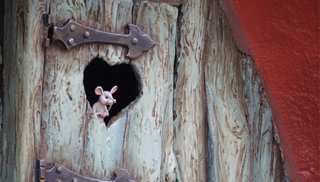 Een muisje kijkt door de deur in het Kabouterdorp in de Efteling.