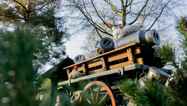 De kar van de melkboer staat er verlaten bij. De kippen en de melkbussen wankelen heen en weer