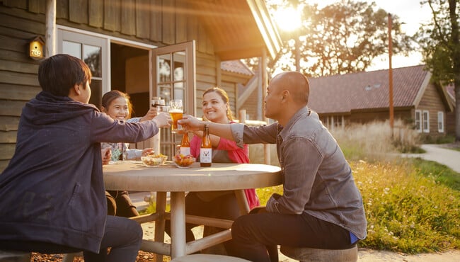 Familie buiten aan het drinken in de zon bij Vakantiepark Efteling Loonsche Land