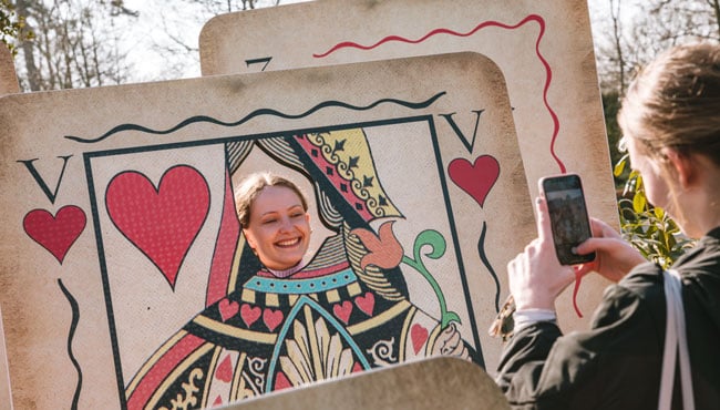 Meisjes maken foto's bij levensgrote spelkaarten