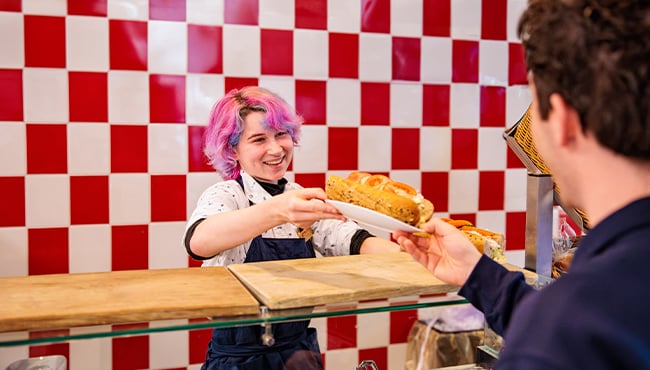 Efteling-medewerker overhandigt broodje in het personeelsrestaurant.