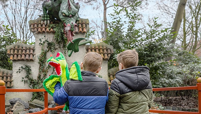 kindjes met draak knuffel bij draak in het sprookjesbos