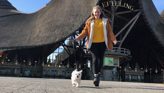 Vrouw met haar hond voor de hoofdentree van de Efteling