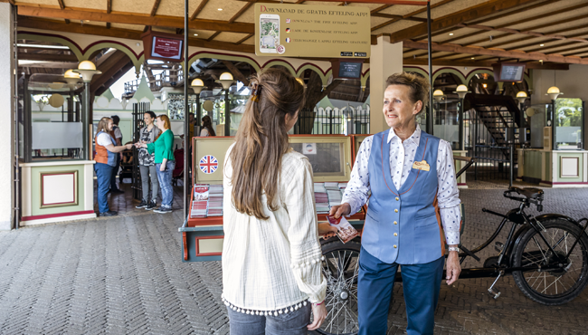 Een Efteling-medewerker deelt een plattegrond uit.