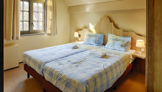 De comfortabele bedden van de slaapkamers in Vakantiepark Efteling Bosrijk zijn al voor je opgemaakt