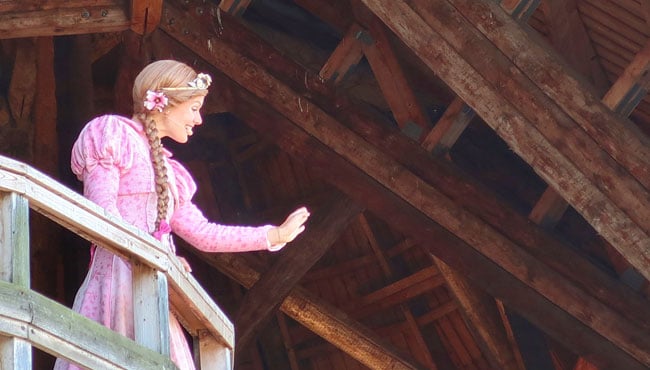 Assepoester zwaait naar gasten in de Efteling.