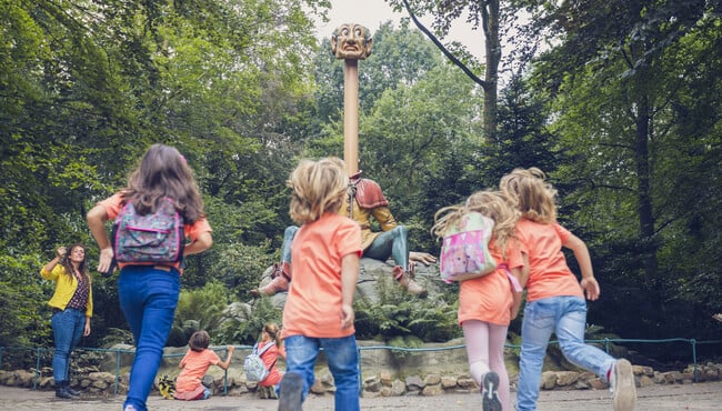 Leerlingen op schoolreis in de Efteling rennend naar Langnek in het Sprookjesbos