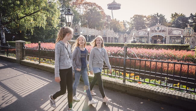 Drie vriendinnen lopen door de Efteling in de herfst.