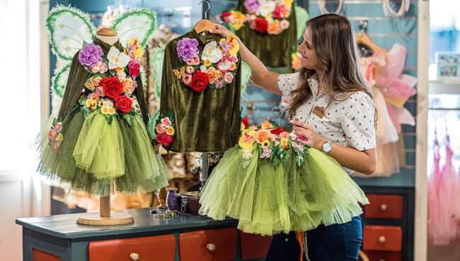 medewerker hangt verkleedkleren op in de winkel spiegeltje spiegeltje