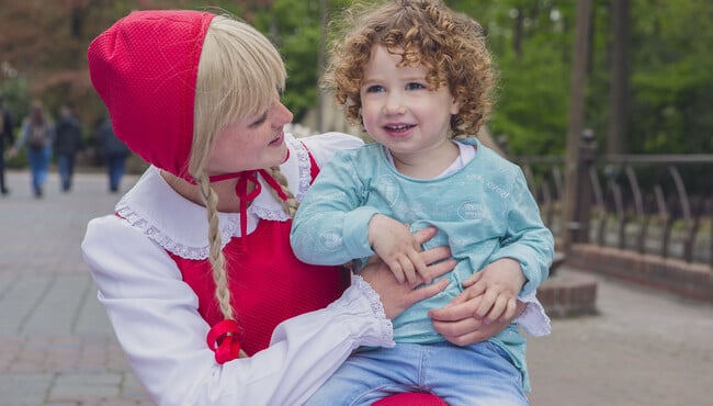 kindje zit op schoot bij roodkapje