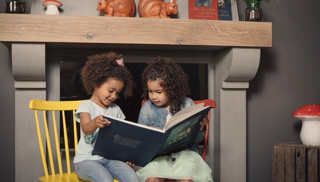 Twee meisjes lezen in een sprookjesboek