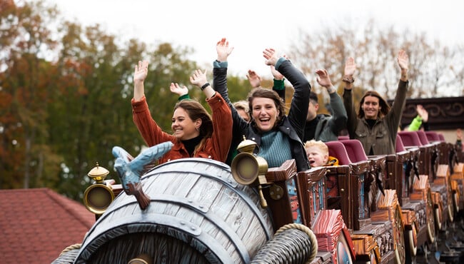 Mensen met hun armen omhoog in een achtbaantrein van achtbaan Max & Moritz in de Efteling.