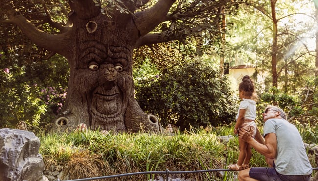 Opa met kleindochter kijken naar de Sprookjesboom in de Efteling.