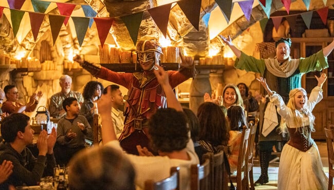 Gasten aan tafel in restaurant Het Wapen van Raveleijn bij het feest van Ruiter Thomas, de Herbergier en Samira.