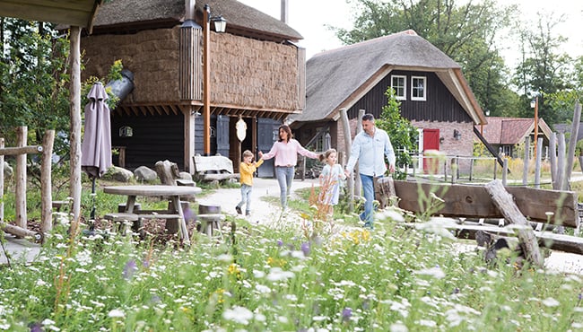 Gezin loopt door vakantiepark Efteling Loonsche Land.