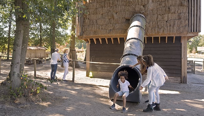 Kind glijdt van een glijbaan in vakantiepark Efteling Loonsche Land.