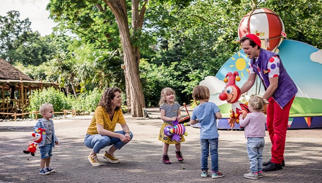 Efteling-karakter Jokie met kinderen op een plein.