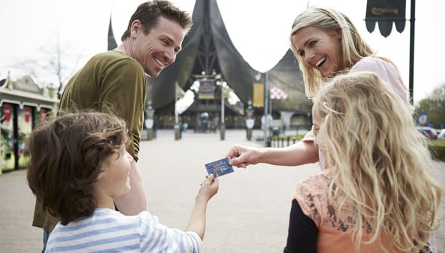 Een gezin met een Efteling Abonnement loopt richting de hoofdentree van de Efteling.