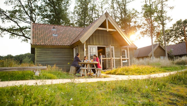 Een hut in Vakantiepark Efteling Loonsche Land met familie in het zonnetje.