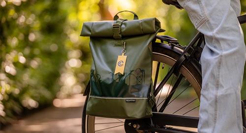 Een groene fietstas van de Efteling hangt aan een fiets.