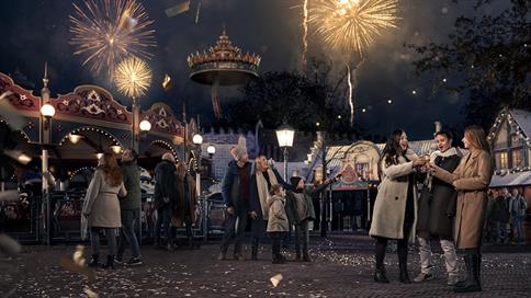 Oud en nieuw in de Efteling met gasten op het Anton Pieck Plein en vuurwerk op de achtergrond