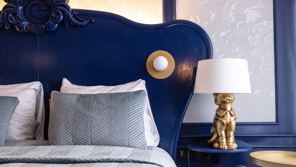Bed met nachtkastje en lamp in Comfortkamer voor twee personen in het Efteling Hotel