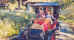 Gezin rijdt een rondje in attractie De Oude Tuffer in de Efteling