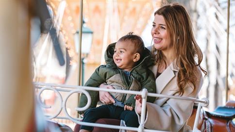 Moeder en zoon in een carrousel op het Anton Pieckplein