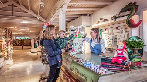 Medewerkster Marskramer geeft tasje aan gasten